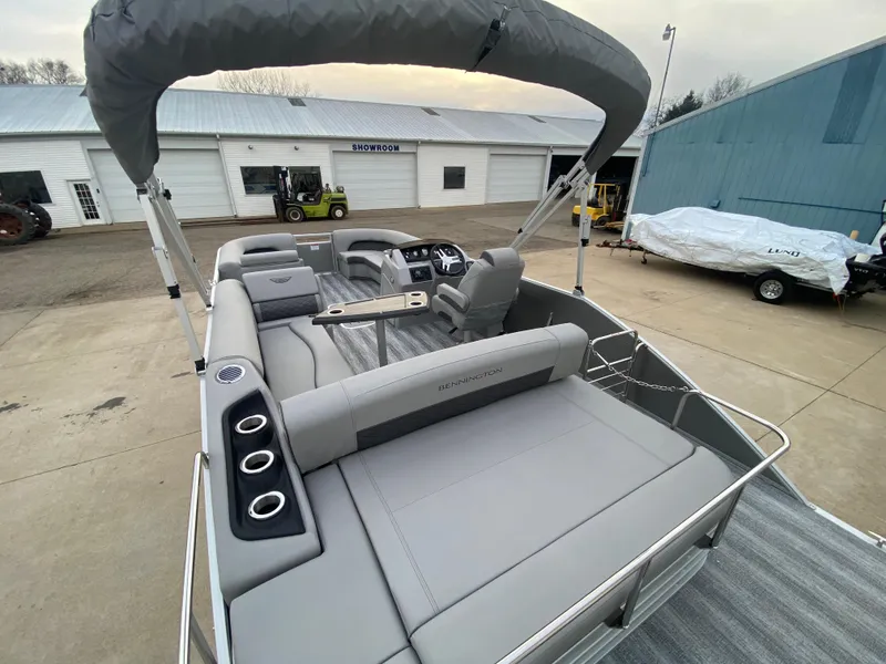 Slide: The Image of 2025 Bennington 23 LSB pontoon boat with gray seating and canopy in a marina. - 33