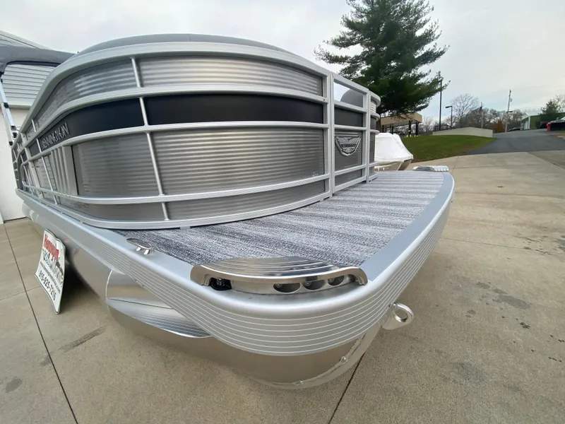 Slide: The Image of 2025 Bennington 23 LSB pontoon boat, sleek silver design, parked on concrete. - 35