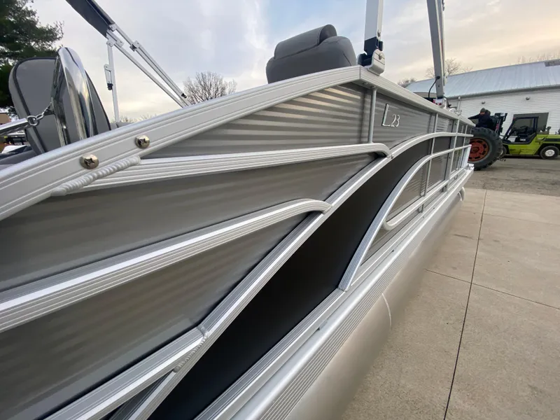 Slide: The Image of 2025 Bennington 23 LSB pontoon boat with sleek silver design on a concrete surface. - 37