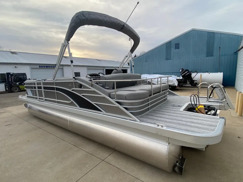 Slide: The Image of 2025 Bennington 23 LSB pontoon boat with canopy, docked outdoors. - 5