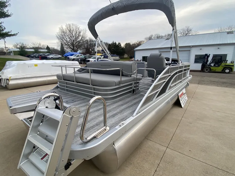 Slide: The Image of 2025 Bennington 23 LSB pontoon boat with canopy, parked outdoors. - 8
