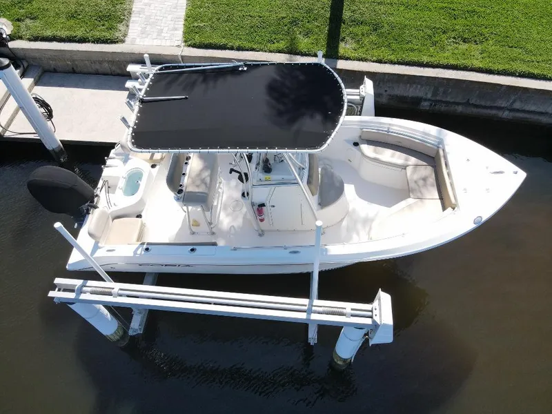 Slide: The Image of 2016 Cobia 217 Center Console boat docked on a lift, aerial view. - 2