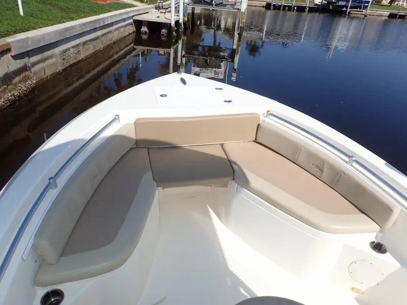Slide: The Image of 2016 Cobia 217 Center Console boat with cushioned seating, docked by calm waters. - 20