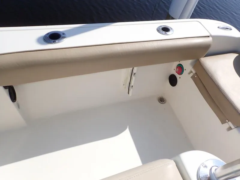 Slide: The Image of 2016 Cobia 217 Center Console boat interior with beige seating and rod holders. - 22