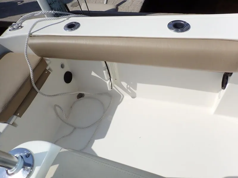 Slide: The Image of 2016 Cobia 217 Center Console boat interior with beige seating and rope detail. - 23