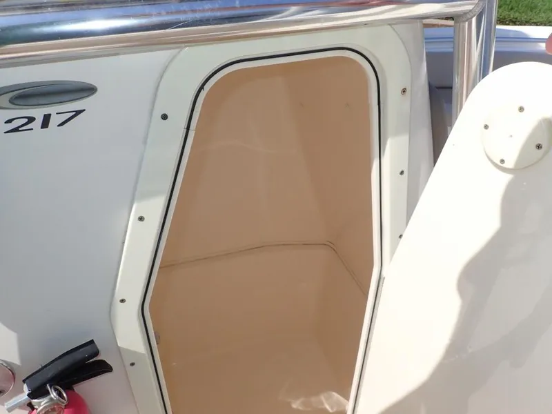 Slide: The Image of 2016 Cobia 217 Center Console storage compartment with open door. - 25