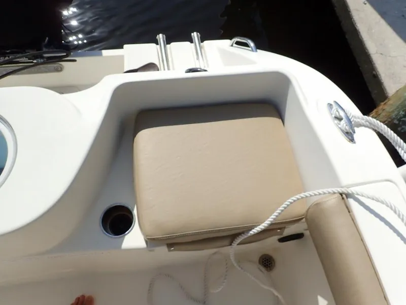 Slide: The Image of 2016 Cobia 217 Center Console boat seating area with beige cushion and rope detail. - 32