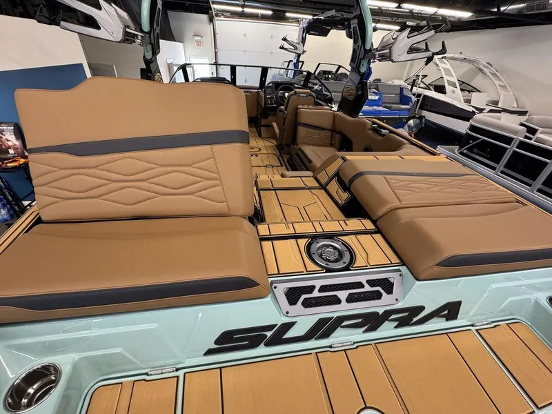 Slide: The Image of 2025 Supra SL 450 boat interior with tan seating and wood finish. - 11