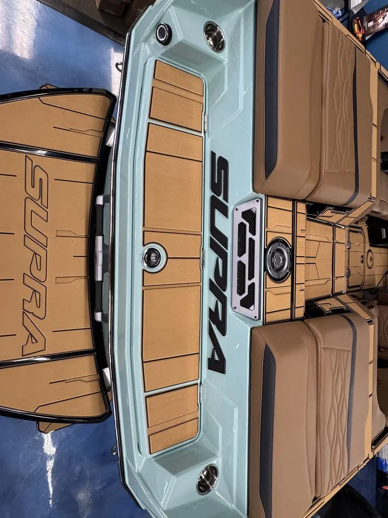Slide: The Image of 2025 Supra SL 450 boat interior with tan seating and branded flooring. - 9