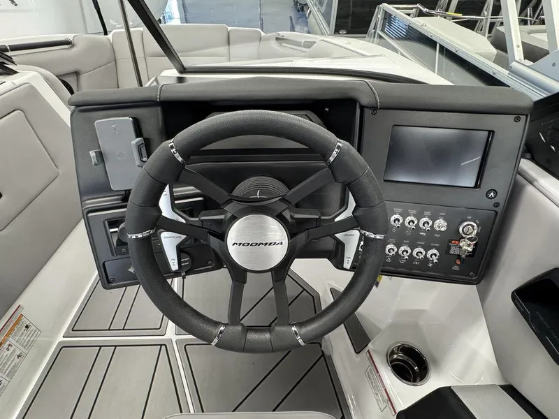 Slide: The Image of 2025 Moomba Mondo boat dashboard with steering wheel and control panel. - 16