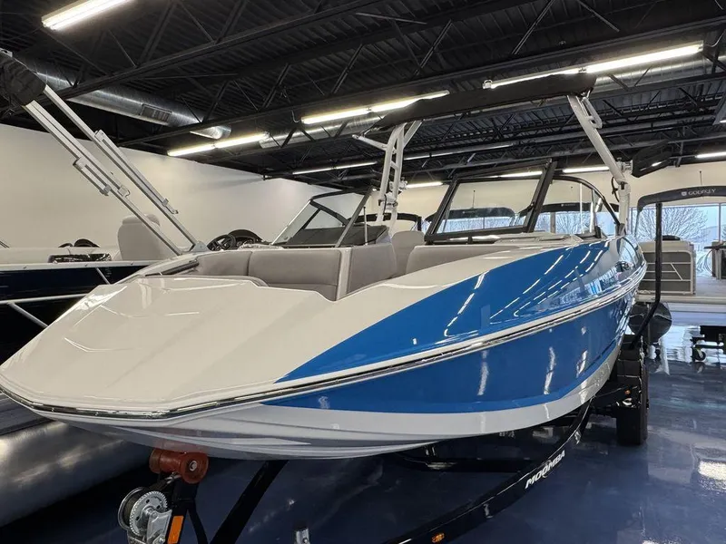 Slide: The Image of 2025 Moomba Mondo boat in showroom, featuring sleek blue and white design. - 9