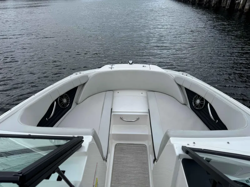 Slide: The Image of 2023 Sea Ray 190SPXO boat interior with white seating, on calm water. - 10