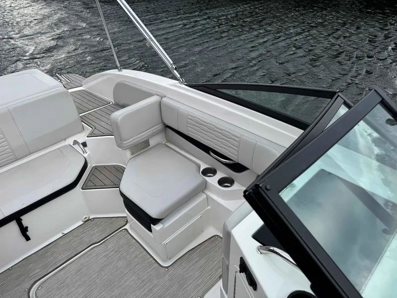 Slide: The Image of 2023 Sea Ray 190SPXO boat interior with white seating and cup holders on water. - 7