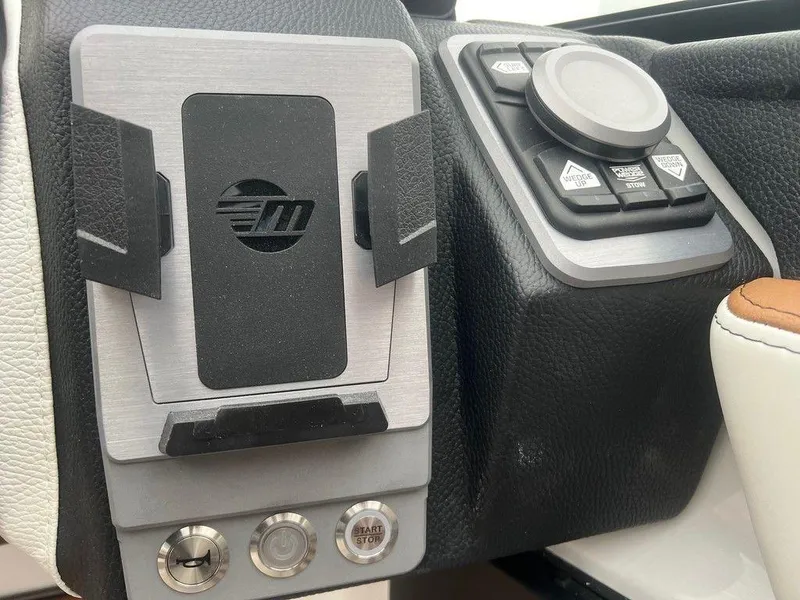 Slide: The Image of 2025 Malibu 23 MXZ dashboard with control panel and phone holder. - 11