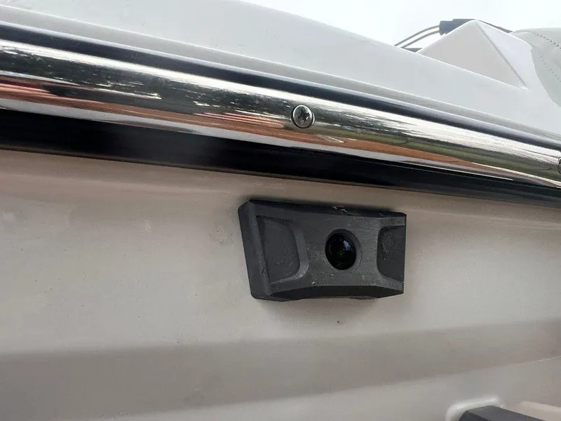 Slide: The Image of 2025 Malibu 23 MXZ boat detail with mounted camera on white hull. - 19