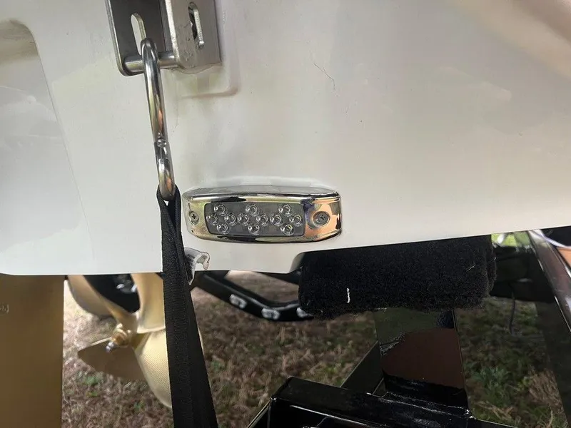 Slide: The Image of Close-up of 2025 Malibu 23 MXZ boat's rear hardware and propeller. - 23
