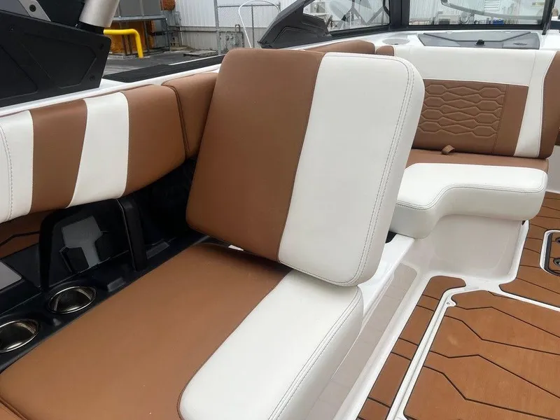Slide: The Image of 2025 Malibu 23 MXZ boat interior with brown and white seating. - 7
