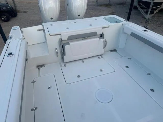 Slide: The Image of 2025 Parker 2420 Sport Cabin boat deck with foldable seat and storage compartments. - 10