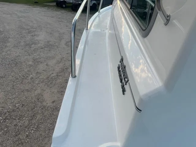 Slide: The Image of 2025 Parker 2420 Sport Cabin boat exterior with railing and logo. - 7