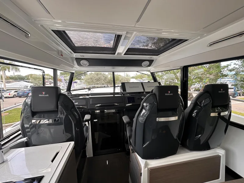 Slide: The Image of 2023 Wellcraft 355 boat cockpit with Garmin navigation displays and modern steering wheel. - 10