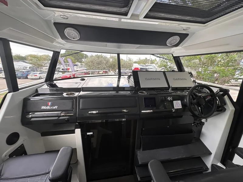 Slide: The Image of 2023 Wellcraft 355 helm with Garmin displays and modern controls. - 11