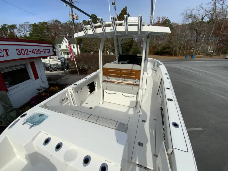 Slide: The Image of 2025 Pursuit S 288 Sport boat with spacious deck and seating, parked outdoors. - 11