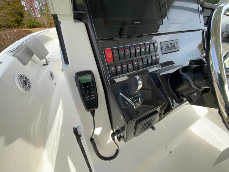 Slide: The Image of 2025 Pursuit S 288 Sport boat dashboard with controls and radio. - 14