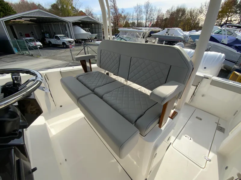 Slide: The Image of 2025 Pursuit S 288 Sport boat with luxurious seating in a marina setting. - 16