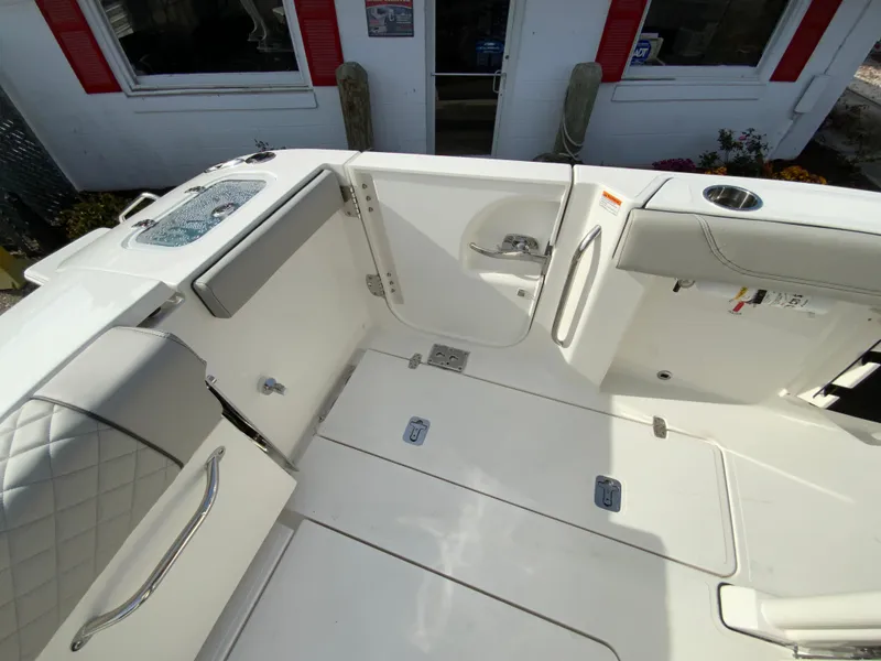 Slide: The Image of 2025 Pursuit S 288 Sport boat interior with white seating and storage compartments. - 21