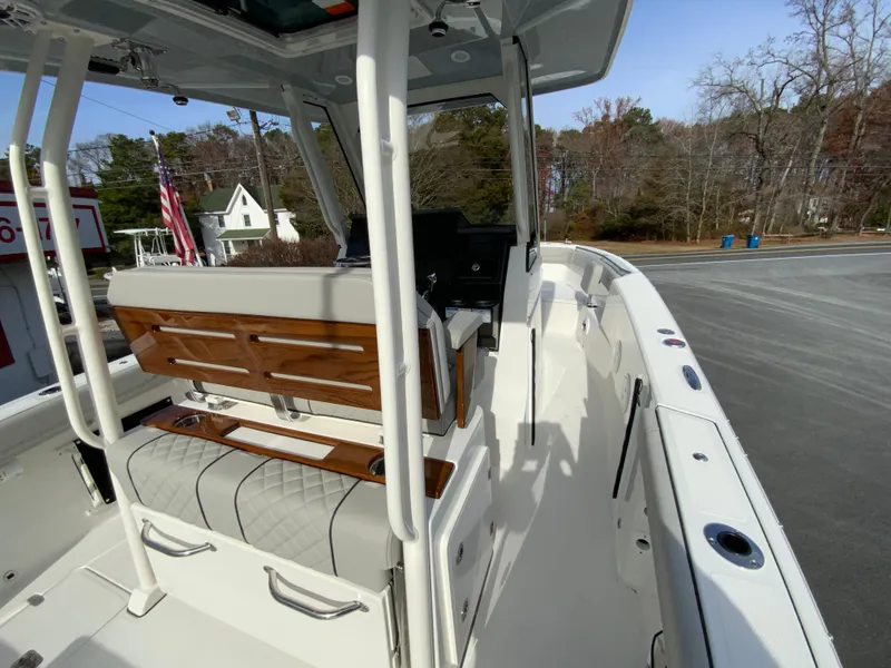 Slide: The Image of 2025 Pursuit S 288 Sport boat interior with seating and helm, docked outdoors. - 25