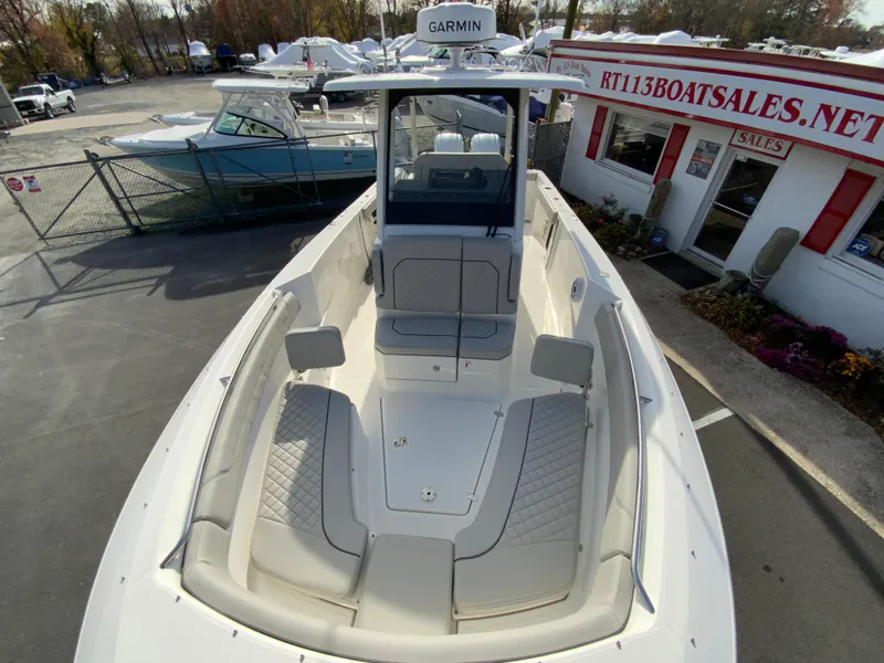 Slide: The Image of 2025 Pursuit S 288 Sport boat at dealership, featuring spacious deck and modern design. - 33