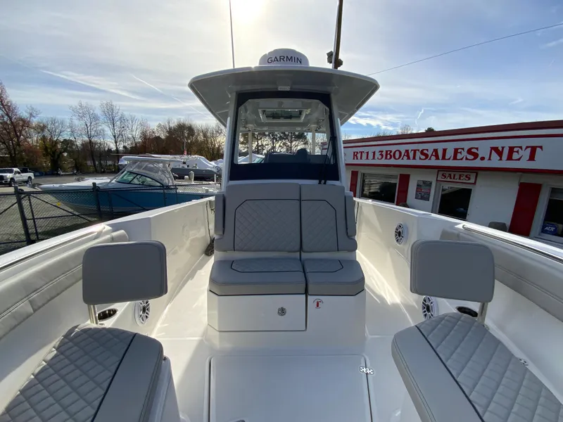 Slide: The Image of 2025 Pursuit S 288 Sport boat interior at dealership, featuring seating and Garmin equipment. - 34