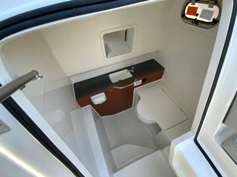 Slide: The Image of 2025 Pursuit S 288 Sport boat interior with compact bathroom and sink. - 37