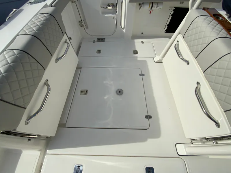 Slide: The Image of 2025 Pursuit S 288 Sport boat interior with cushioned seating and storage compartments. - 43