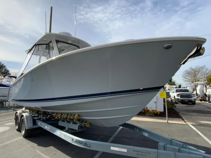 Slide: The Image of 2025 Pursuit S 288 Sport boat on trailer, parked outdoors under cloudy sky. - 47