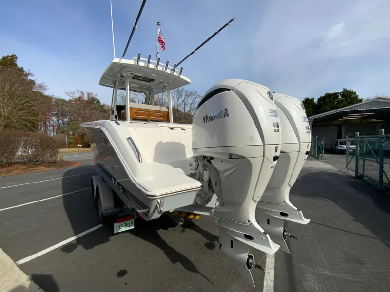Slide: The Image of 2025 Pursuit S 288 Sport boat with dual outboard engines in a parking lot. - 8