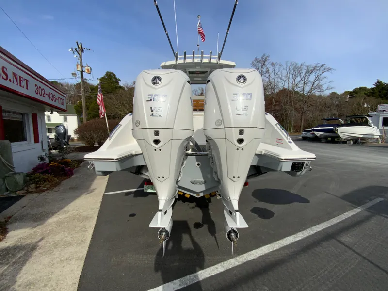 Slide: The Image of 2025 Pursuit S 288 Sport boat with dual outboard engines in a parking lot. - 9