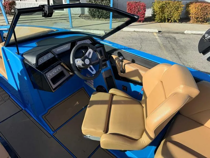 Slide: The Image of 2024 MasterCraft NXT23 boat interior with tan seats and blue accents. - 11