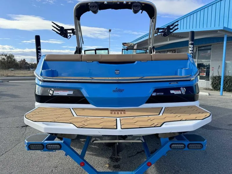Slide: The Image of 2024 MasterCraft NXT23 boat, blue exterior, rear view at a dealership. - 6