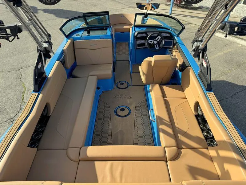 Slide: The Image of 2024 MasterCraft NXT23 boat interior with tan seating and blue accents. - 9