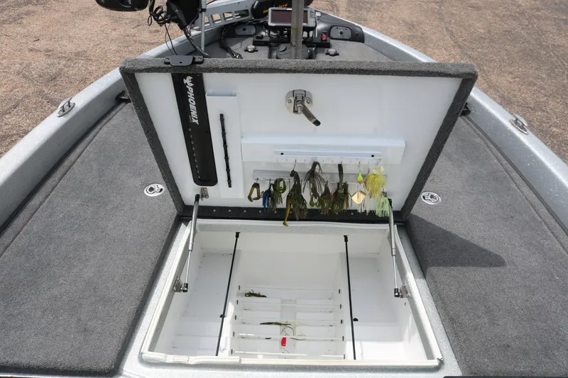 Slide: The Image of 2016 Phoenix 920 ProXP boat interior with green and gray seating and open storage compartment. - 24