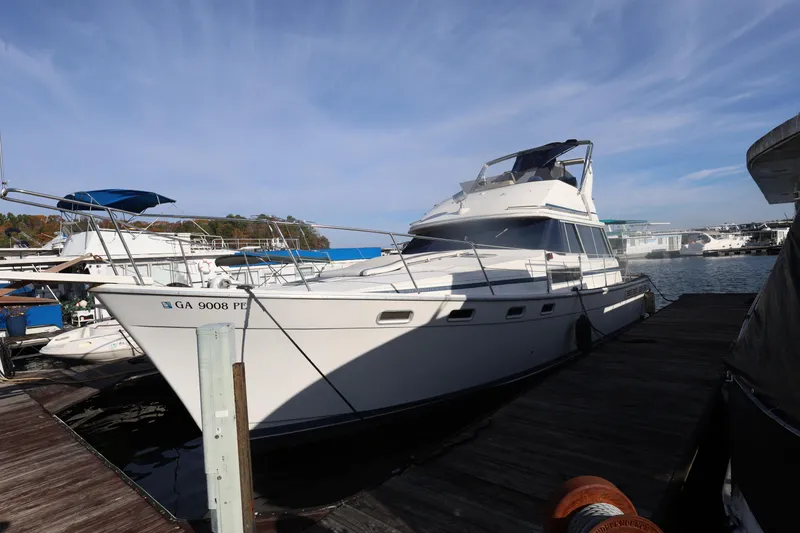 Slide: The Image of 1988 Bayliner 3818 Motoryacht docked at marina under clear sky. - 2
