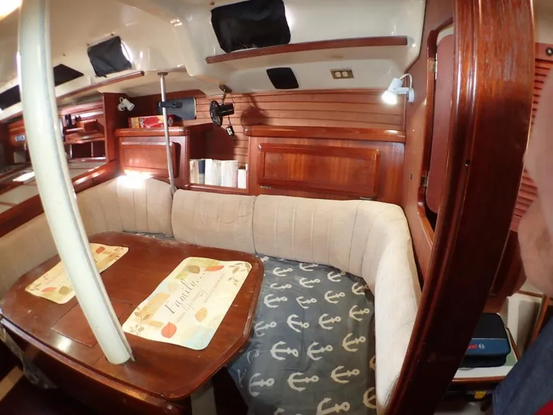 Slide: The Image of Cozy interior of 1991 Hunter Legend 37.5 sailboat with wood finish and cushioned seating. - 37