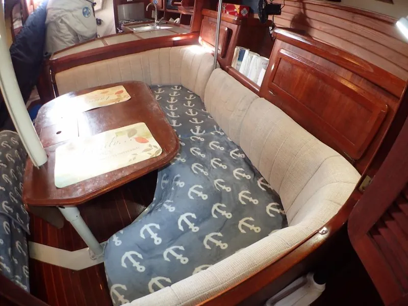 Slide: The Image of Interior of 1991 Hunter Legend 37.5 sailboat with anchor-patterned seating and wooden table. - 38
