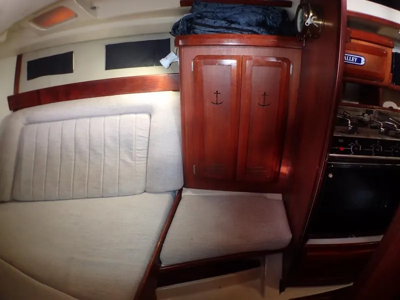 Slide: The Image of Interior of 1991 Hunter Legend 37.5 sailboat with wood cabinets and cushioned seating. - 45