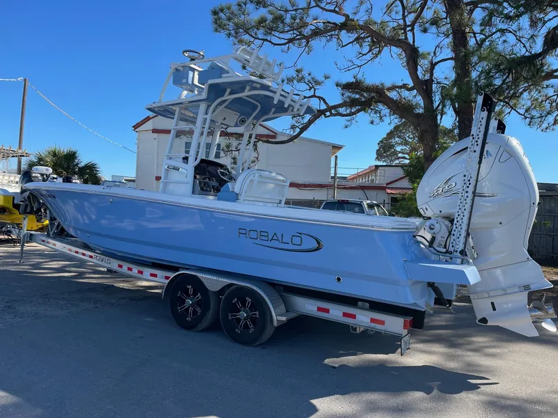 The Image of 2023 Robalo 266 Cayman SD boat on trailer, parked outdoors. - 0