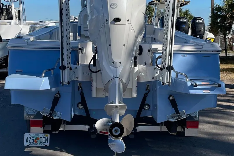 Slide: The Image of 2023 Robalo 266 Cayman SD boat rear view with outboard motor and trailer. - 4