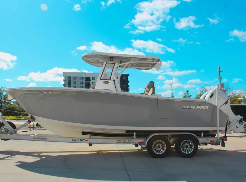 Slide: The Image of 2023 Seapro 259 boat on trailer under clear blue sky. - 0