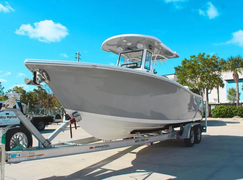 Slide: The Image of 2023 Seapro 259 boat on trailer under clear blue sky. - 1