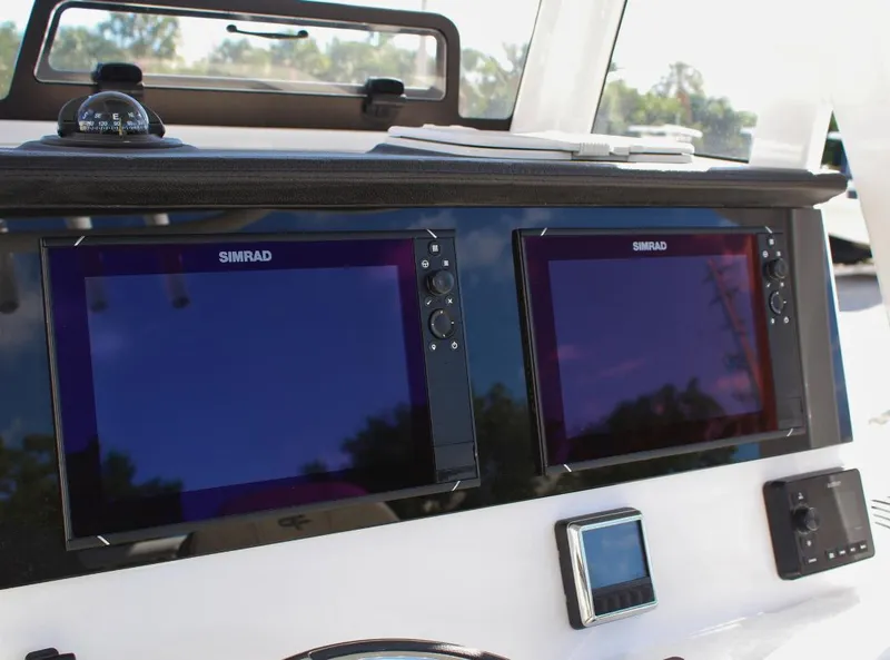 Slide: The Image of 2023 Seapro 259 boat dashboard with dual Simrad displays and navigation controls. - 14
